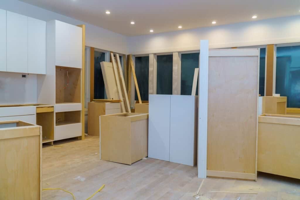 Interior construction site with cabinetry and wood panels in progress.